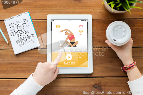 Image of close up of woman with tablet pc on wooden table