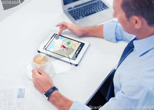 Image of businessman with tablet pc and coffee in office