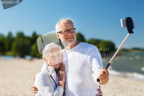 Image of happy senior couple hugging on summer beach