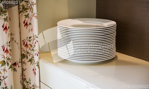 Image of close up of plates on cupboard shelf