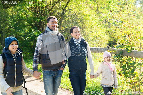 Image of happy family with backpacks hiking in woods