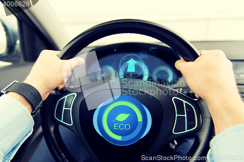 Image of close up of young man driving car in eco mode