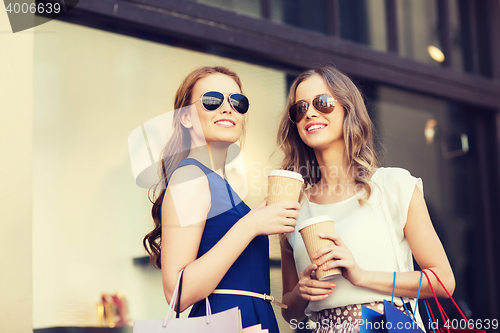 Image of young women with shopping bags and coffee at shop