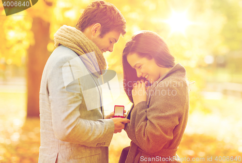 Image of man proposing to a woman in the autumn park