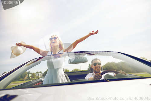 Image of happy man and woman driving in cabriolet car