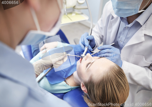 Image of close up of dentist treating female patient teeth