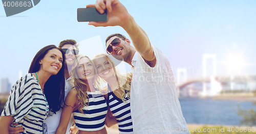 Image of happy friends taking selfie by smartphone in tokyo