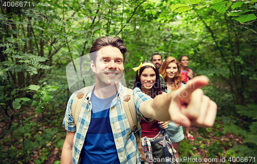 Image of group of smiling friends with backpacks hiking