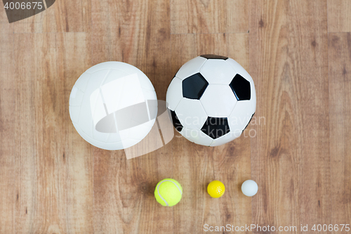 Image of close up of different sports balls set on wood