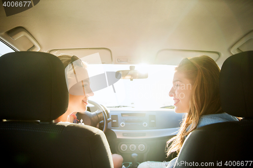 Image of happy teenage girls or women in car at seaside