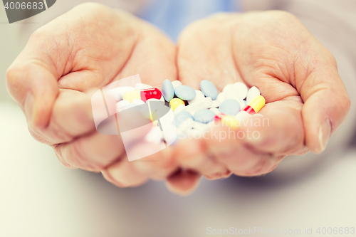 Image of close up of senior woman hands with pills