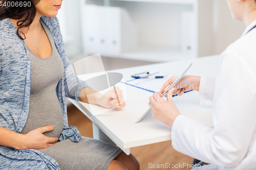 Image of close up of doctor with tablet and pregnant woman