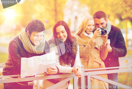 Image of couples with tourist map and camera in autumn park