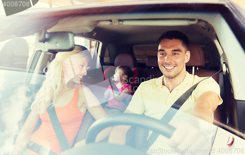 Image of happy family with little child driving in car