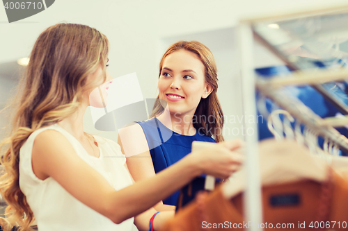 Image of happy women with shopping bags at clothing shop