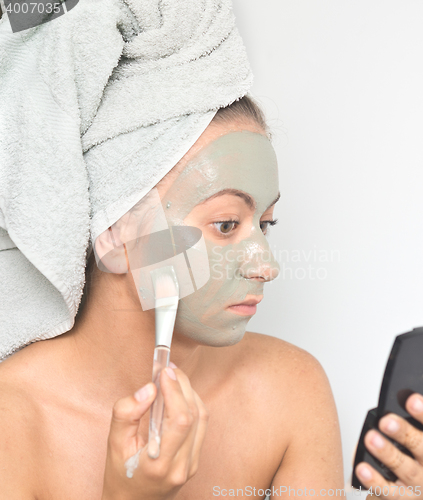 Image of woman applying mask