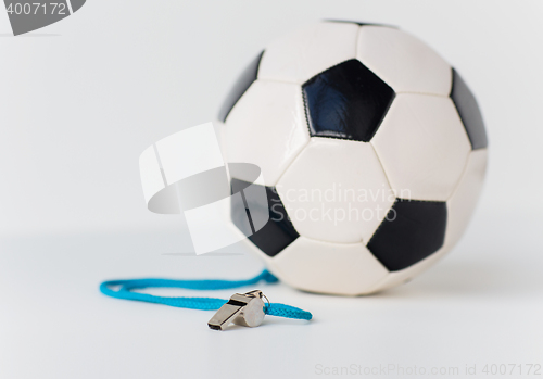 Image of close up of football or soccer ball and whistle