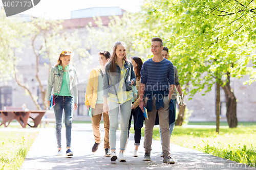 Image of group of happy teenage students walking outdoors