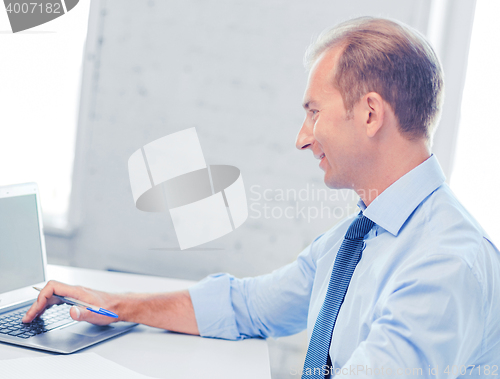 Image of smiling businessman working in office