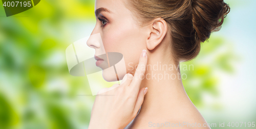 Image of beautiful woman pointing finger to her ear