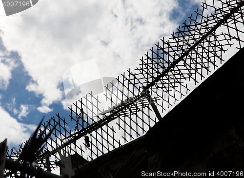 Image of close up of fence with barbed wire and mesh