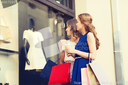 Image of young women with shopping bags and coffee at shop