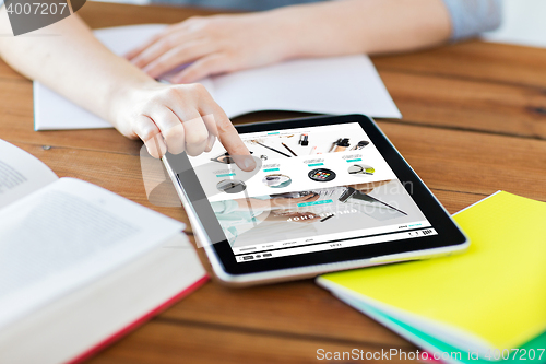 Image of close up of student with tablet pc and notebook