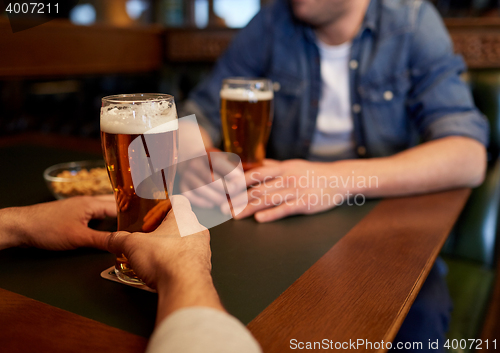 Image of close up of men drinking beer at bar or pub