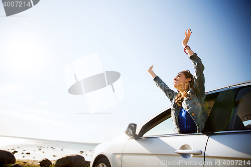 Image of happy teenage girl or young woman in car