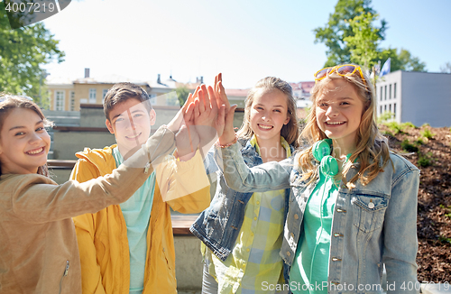 Image of happy students or friends making high five