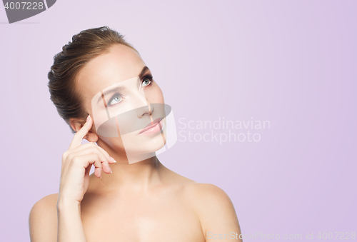 Image of beautiful young woman touching her face