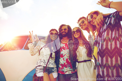 Image of hippie friends over minivan car showing peace sign