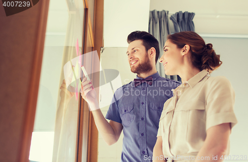 Image of creative team with stickers on glass at office