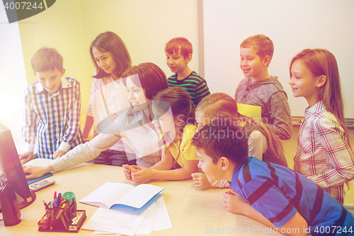 Image of group of kids with teacher and computer at school