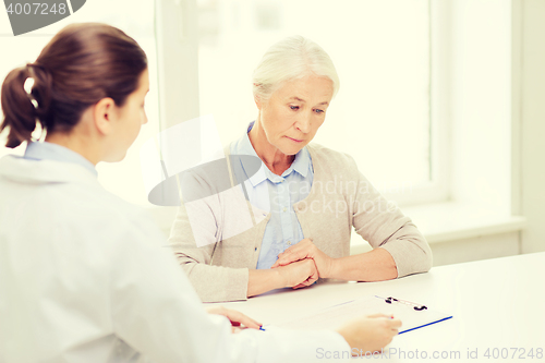 Image of doctor with clipboard and senior woman at hospital