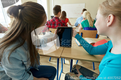 Image of happy student girls with tablet pc at high school