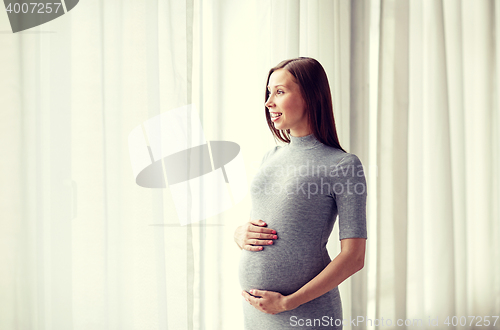 Image of happy pregnant woman with big tummy at home