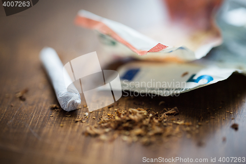 Image of close up of marijuana joint and money