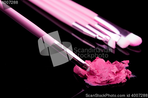 Image of lipstick with a brush make-up on black 