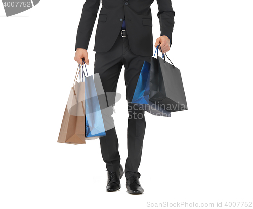 Image of close up of man in suit with shopping bags