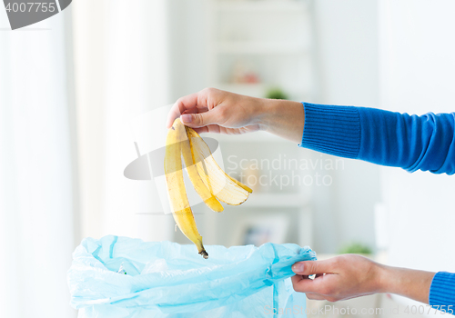 Image of close up of hand putting food waste to rubbish bag