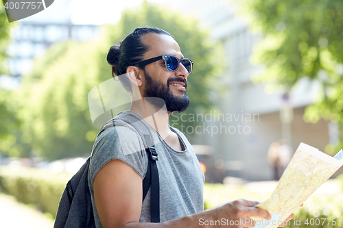 Image of man traveling with backpack and map in city