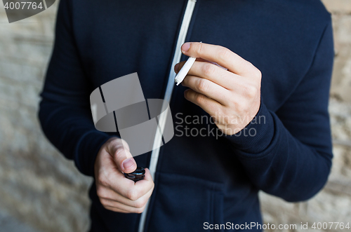 Image of close up of addict hands with marijuana joint