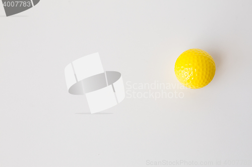 Image of close up of yellow golf ball over white background