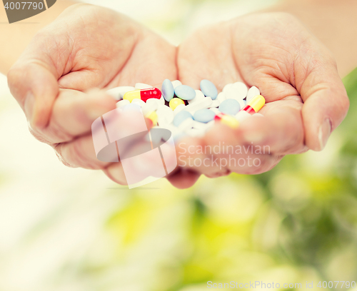 Image of close up of senior woman hands with pills