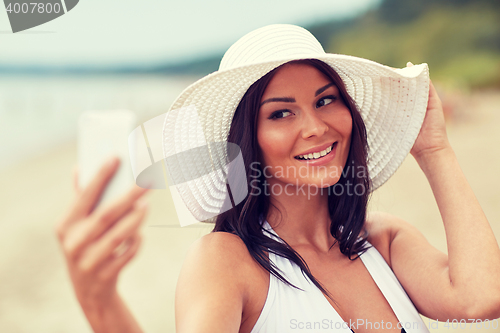 Image of young woman taking selfie with smartphone