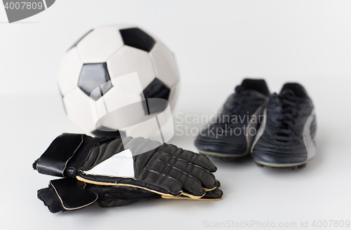 Image of close up of goalkeeper gloves, ball, soccer boots