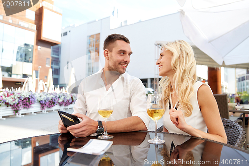 Image of happy couple with wallet paying bill at restaurant