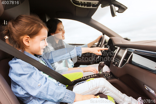 Image of happy woman with little child driving in car