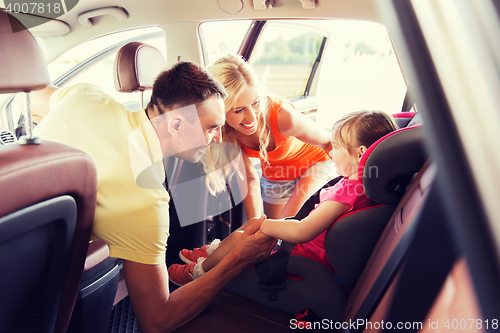 Image of parents talking to little girl in baby car seat